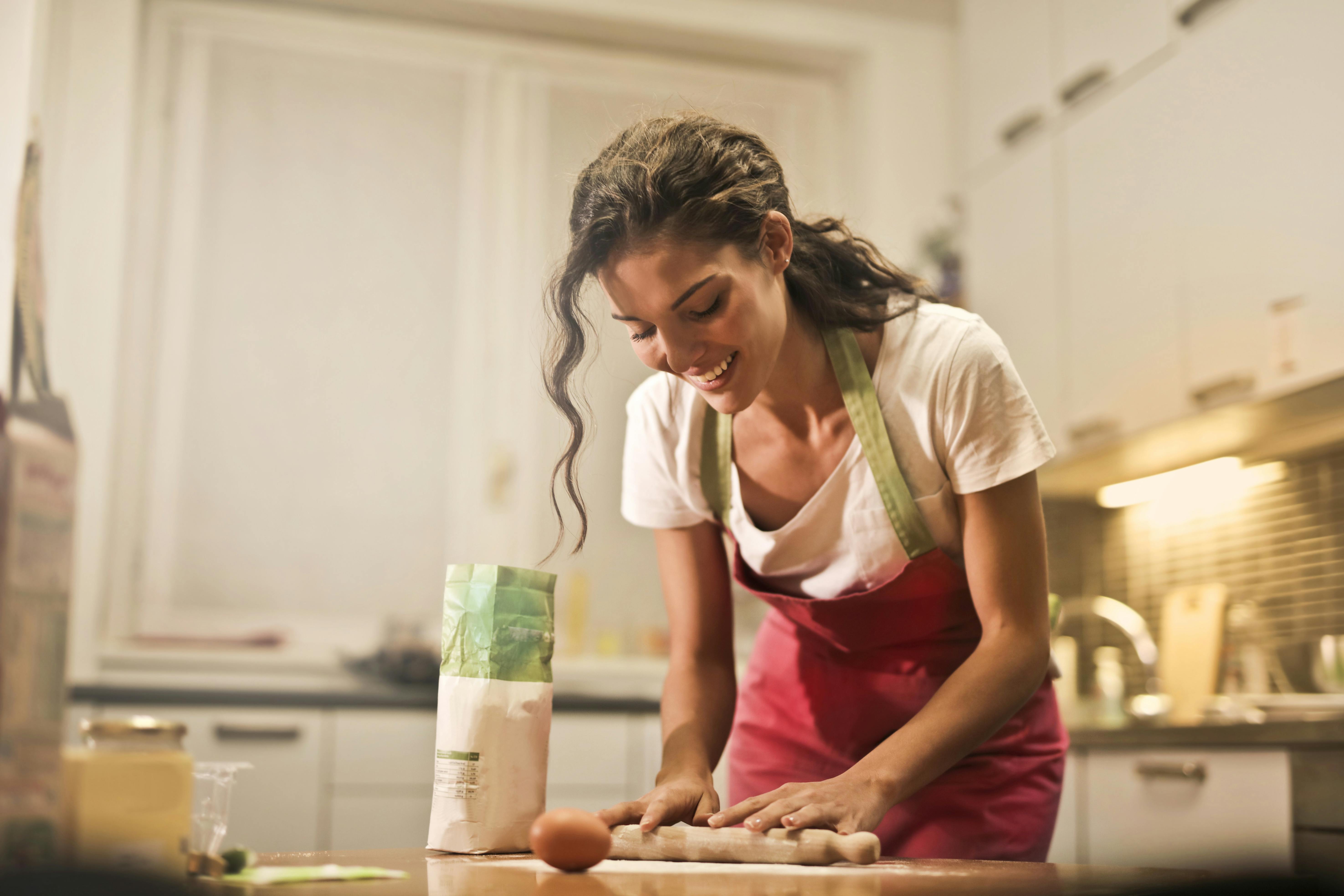 A woman happily baking in the kitchen
